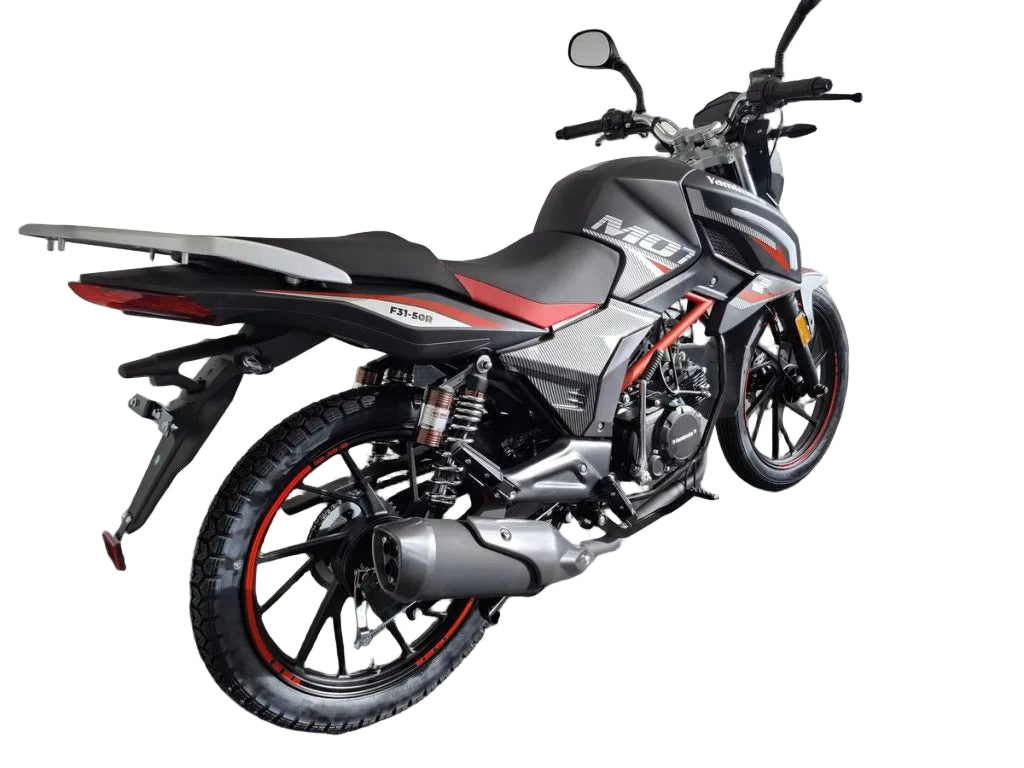 A black and gray yamimoto M10 TD-Ci motorcycle with red accents, photographed in a showroom or garage setting against a white brick wall.