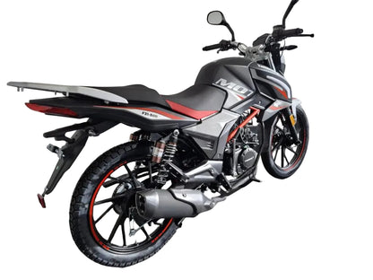 A black and gray yamimoto M10 TD-Ci motorcycle with red accents, photographed in a showroom or garage setting against a white brick wall.