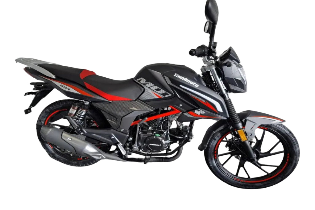 A black and red yamimoto motorcycle parked in a garage corner with a white brick wall and gray floor.